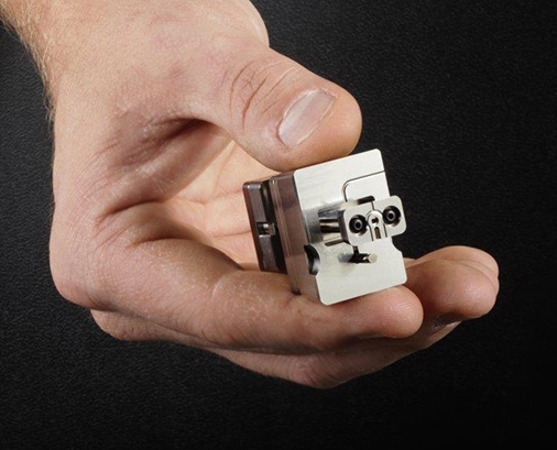 Image of human hand holding micro tooling part from Isometric Micro Molding