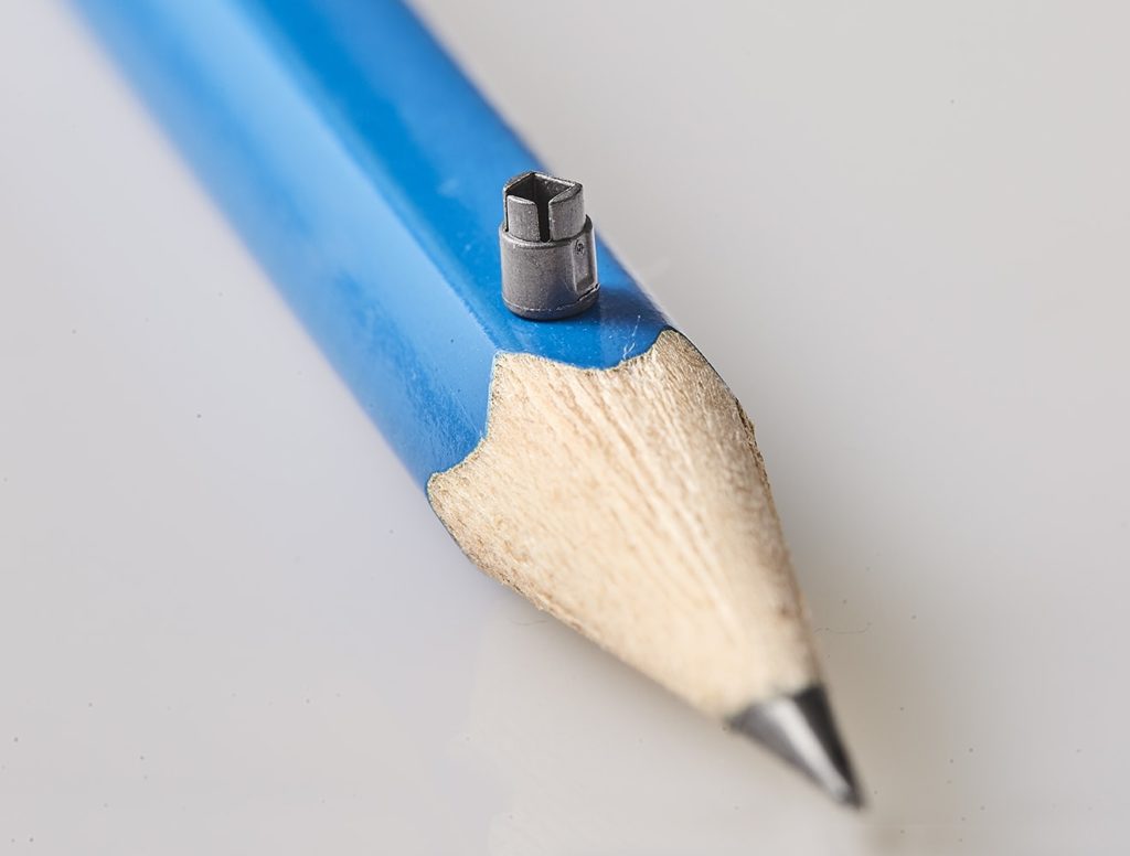 Photo of a micro surgical component for robotic surgery medical devices, shown on the tip of a pencil, by Isometric Micro Molding