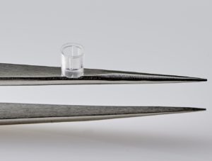 Photo of micro surgical tool component for robotic surgery medical devices, shown on a tweezer tip, by Isometric Micro Molding